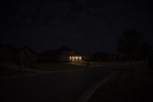 Shows a neighborhood with power outage. One home with lights.