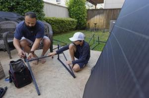 A father and son installing plug-in solar.