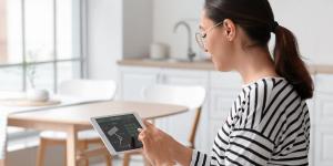 a women holding a tablet with a smart security app
