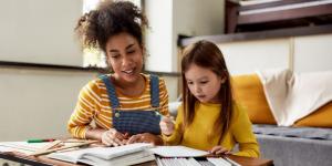 a Babysitter is helping a toddler doing homework