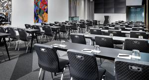 Linenless meeting setup featuring Southern Aluminum tables and Ramler chairs