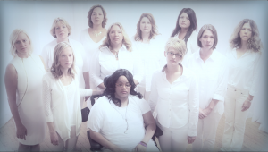 Survivors of intimate partner homicide attempts whose stories were featured in the documentary film, Finding Jenn's Voice, gather as a group dressed in white looking to camera