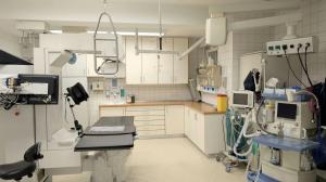 Sala di radiologia ospedaliera con apparecchiatura diagnostica e lettino per pazienti.