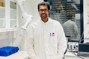 Doctoral Researcher Sachin Kochrekar standing in a laboratory wearing a white laboratory coat.