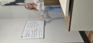 The owner's daughter writes her favorite Bible scripture on a dry erase board inside MRS Restoration's downtown Blue Ridge office, reflecting the family-owned culture of the North Georgia restoration company.