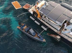 Ariel photo of sailing yacht on anchor with an IRON tender tied up with it