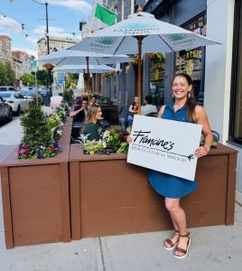 Francine Urda of Francine’s Horticultural Services standing beside the flower-filled Courtside Biergarten outdoor seating area in Downtown Binghamton.