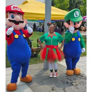 Festival participant posing with costumed characters during the Christmas in July celebration at the All Disabilities Festival in Columbus, Ohio.