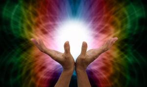 photo of two hands opened and reaching up to light with beautiful colors all around