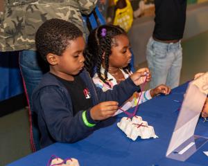Two young children participate in a hands-on STEM activity at the Museum of Discovery and Science’s A Day in K event, exploring problem-solving and early learning skills through interactive play.