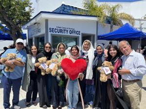 San Diego Islamic Center members standing outside the security office with their weighted therapetuic Comfort Cubs.