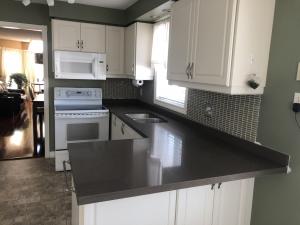 Durable dark quartz kitchen countertops with a tile backsplash, installed by DreamStone Kitchen for a GTA home.