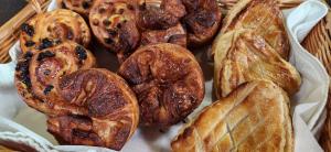 Photo shows basket of artisanal baked goods including custard-filled raisin danishes and kouign-amann.
