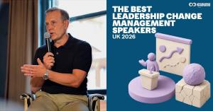 Change management speaker Chris Hirst delivering a keynote on stage in front of a large presentation screen.