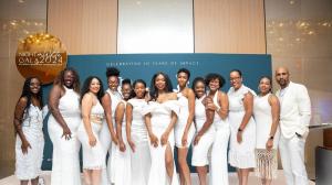 Team members of The White Dress Project, many dressed in white, pose together at the Empowerment Experience, the organization's annual fundraising and awareness event focused on uterine fibroids.