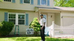 McClouds Window (owner-Nathan) standing in front of a residential house