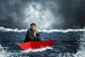 photo a man sitting in an upside down red umbrella on the sea in a bad storm