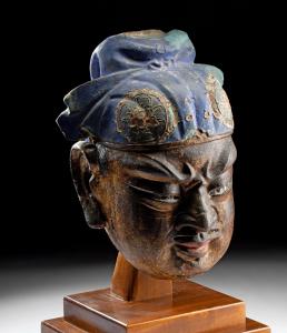 Circa 1368-1644 CE Chinese Ming Dynasty wood and stucco head of a Buddhist guardian deity, 13¼ inches tall. Estimate: $100,000-$150,000