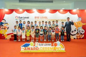 Hong Kong students recognized at the Eye Level Awards Ceremony 2026 pose on stage wearing medals with a Daekyo Hong Kong representative.