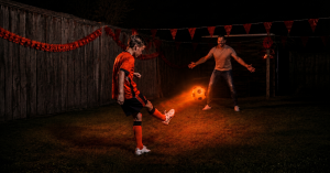 Vader en zoon voetballen samen met lichtgevende voetbal wk