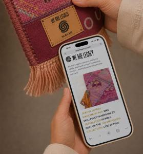 A person scans the NFC-enabled We Are Legacy tag on a handmade Jaipur Rugs textile using a smartphone, accessing digital information about the product's maker, materials, and provenance.