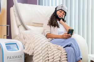Patient wearing a Paxman cold cap receiving machine-based scalp cooling therapy during chemotherapy treatment