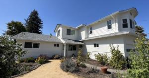 Two-story residential home with newly painted white lap siding, white trim and white stucco.