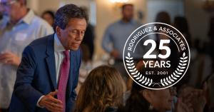 Daniel Rodriguez, Founder and President of Rodriguez & Associates talking with people at a table during his Bench and Bar Award celebration.