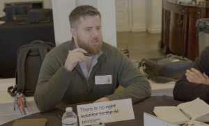 Thomas Corbin leading a discussion at a table during the TeachingAbout.AI convening around what would become the first of the Rochester Provocations: There is no AI problem.
