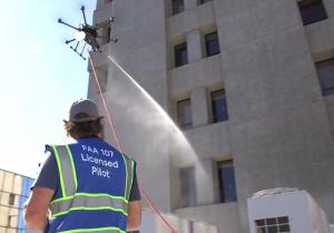 Aqua Drone pilot using drone technology to clean the exterior of a building.