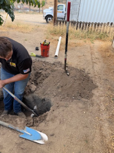 A Rescue Hero Plumbing & Pumping technician manually excavating a site to perform a professional sewer repair.