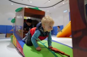 A child participates in a TuniTuni storytelling play class using themed props during a physical activity at a Hong Kong center.