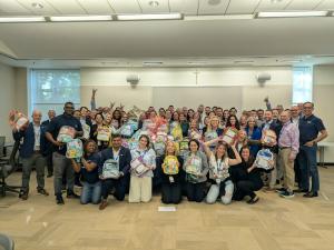 Corporate team posing with completed backpacks during a Strayboots Backpack Drive CSR team-building event.