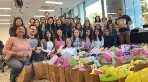 LinkedIn employees standing behind decorated donation bags during a Strayboots CSR giveback activity.