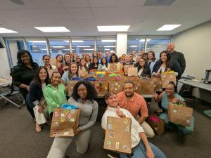 Corporate participants holding decorated paper bags during a Strayboots Build a Bag charity team-building event.