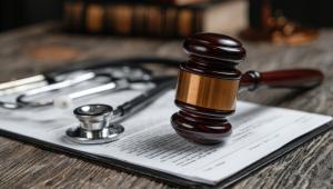 A gavel rests on legal documents beside a stethoscope, symbolizing medical malpractice or healthcare law issues.