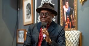 Philip Bailey speaking into a microphone during a fireside chat at the 25th Jazz Hands Concert in Culver City