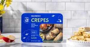 Package of Ptashka Crepes Apples & Vanilla Sauce Crepes displayed alongside plated crepes with apple filling. The flavor was recognized as a 2026 Good Housekeeping Snack Award winner.