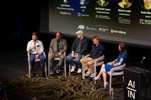 Five panelists seated on stage during the Is Your Agent Human panel at AI Insiders: Cybersecurity, with speaker names and titles displayed on screen above.