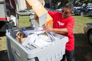 Woman deposits documents into a bin for shredding
