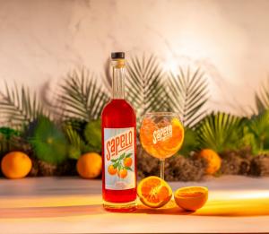 A bottle of Sapelo Aperitivo with a Sapelo Sour Orange and a poured drink.