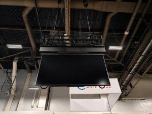 Motorized steel mounting structure holding a 110" flat panel display, capable of lowering the display from the ceiling to viewing level and back up again.