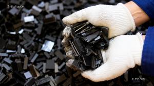 Worker holding sintered NdFeB rare earth permanent magnets used in electric vehicles, renewable energy, industrial automation, aerospace, and defense applications.