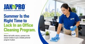 A uniformed commercial cleaner wiping down workstations and high-touch surfaces in a bright open-plan office in Columbus, Georgia, illustrating an ongoing janitorial and office cleaning program