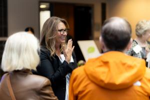 Angela Crocker stands smiling surrounded by other people at a gala reception.