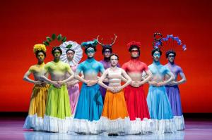 Members of the Atlanta Ballet company portray Frida Kahlo and eight of the alter egos from her imagination in the "Frida" ballet. Rainbow-hued costumes and extraordinary headgear festoon the characters pictured here against a bold red backdrop.