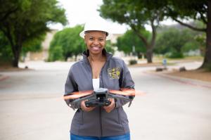 Steffanie Rivers holding a commercial drone while demonstrating drone technology and workforce training opportunities through TCB Drones Academy in Texas.