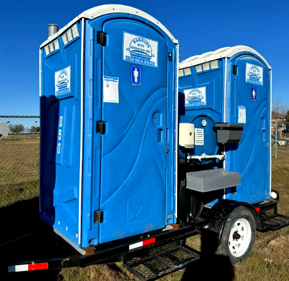 A Barrios Site Services towable trailer with portable toilets and handwash stations for mobile worksite sanitation.