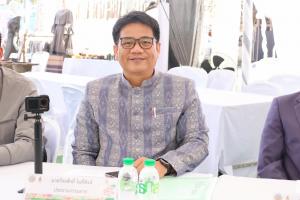 Portrait of Veerasak Phosing, also known as Master Vee, seated at a community event in Thailand wearing a traditional patterned jacket.