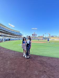 Farrah Mechael and Tamara Mechael standing on the field at Dodger Stadium before a baseball game.